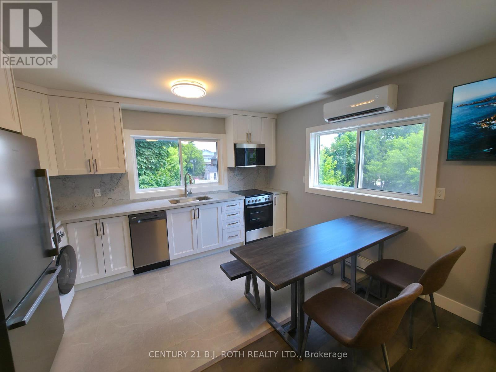 A kitchen with a table and chairs in front of a window.