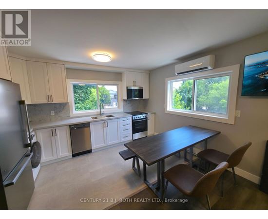 A kitchen with a table and chairs in front of a window.