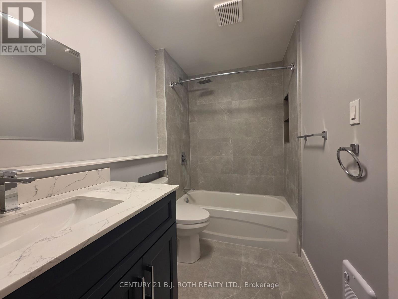 A bathroom with a white sink and a white toilet.