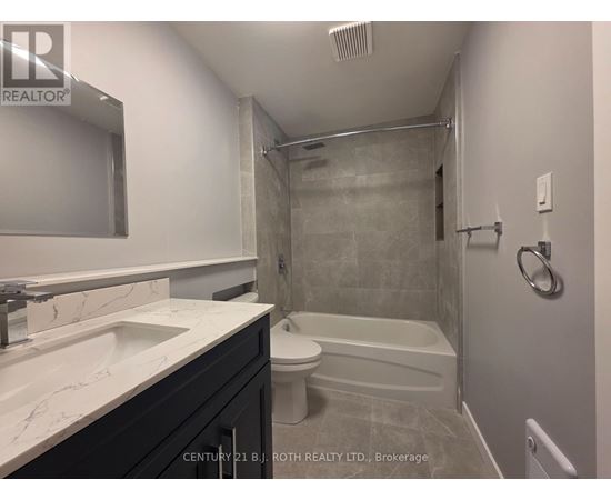 A bathroom with a white sink and a white toilet.