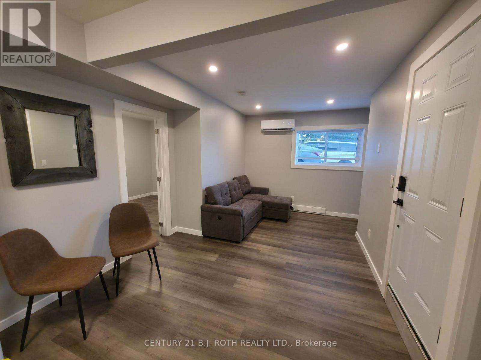 A living room with a brown chair and a grey couch.