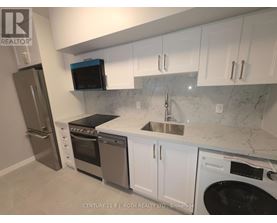 A kitchen with white cabinets and a marble countertop.