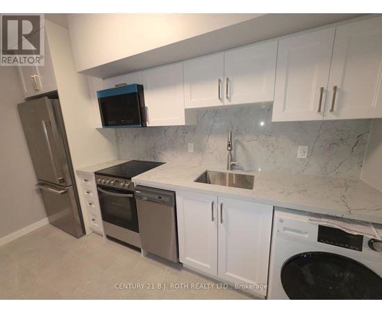 A kitchen with white cabinets and a marble countertop.