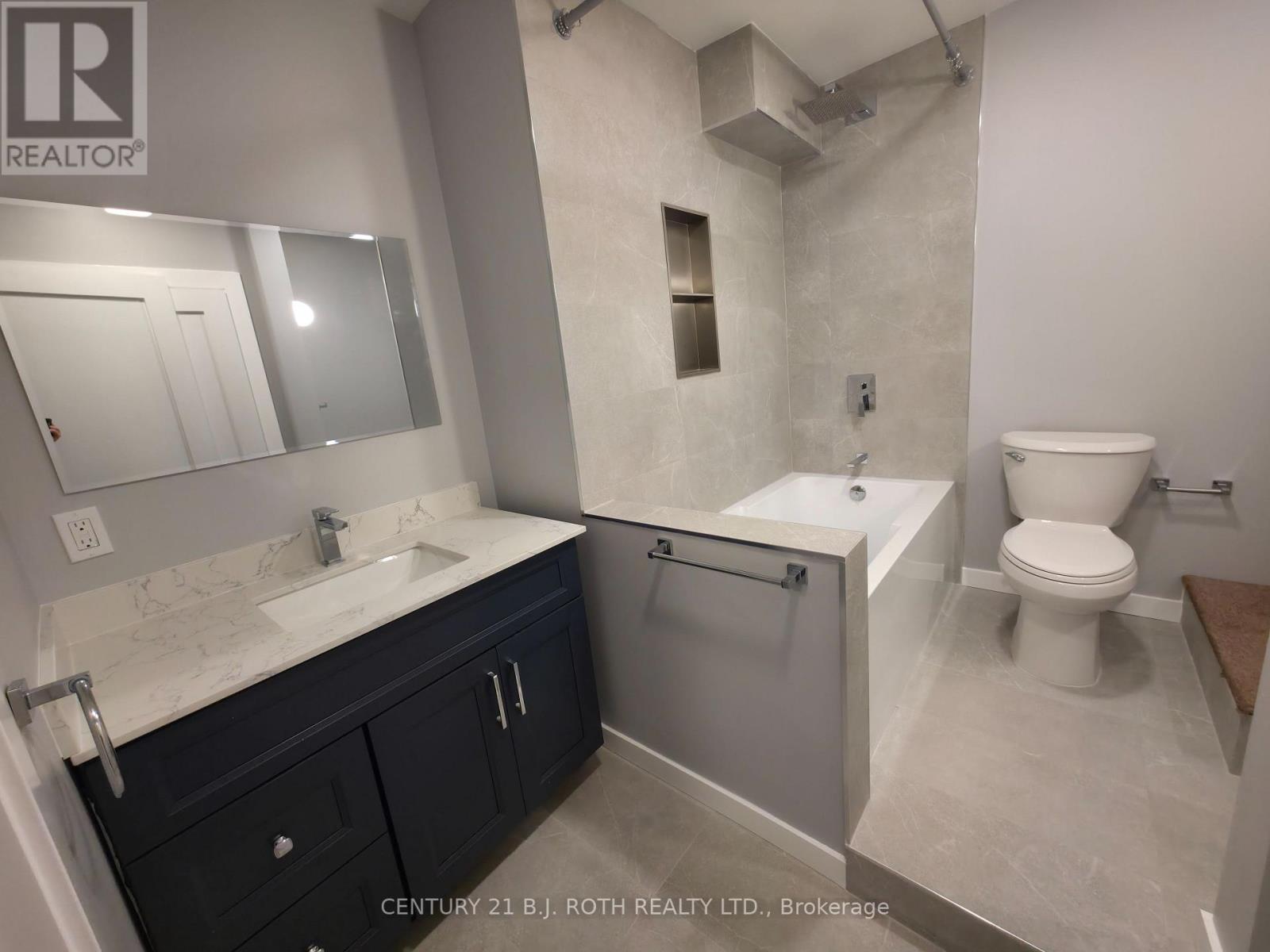 A bathroom with a sink, toilet, and bathtub.