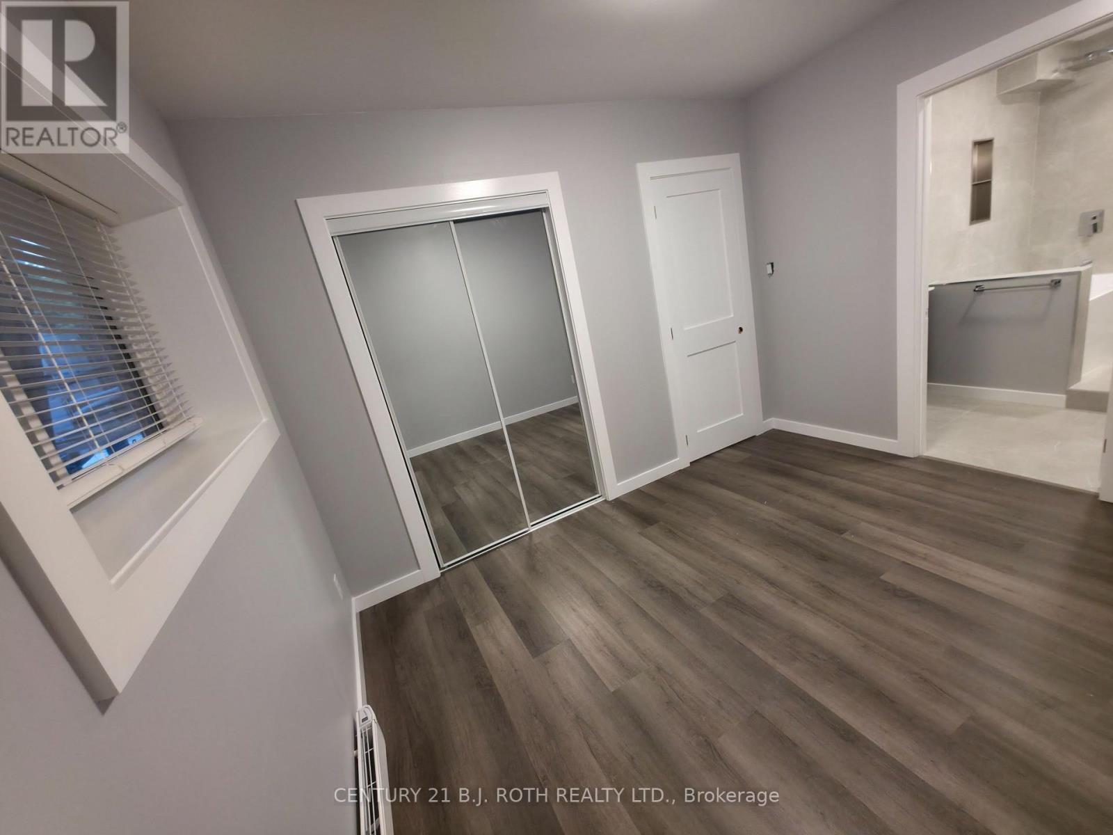 A room with a sliding door and a window with blinds.