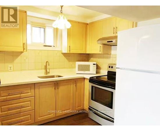 A kitchen with wooden cabinets and a white refrigerator.