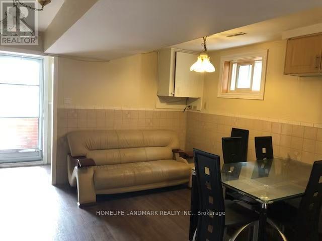 A living room with a couch, chairs, and a dining table.