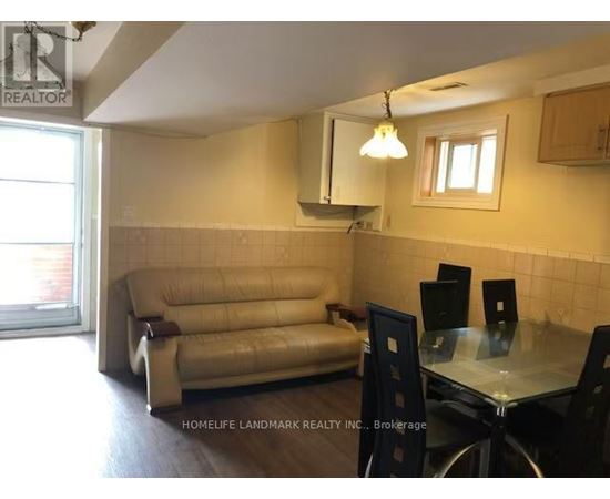 A living room with a couch, chairs, and a dining table.