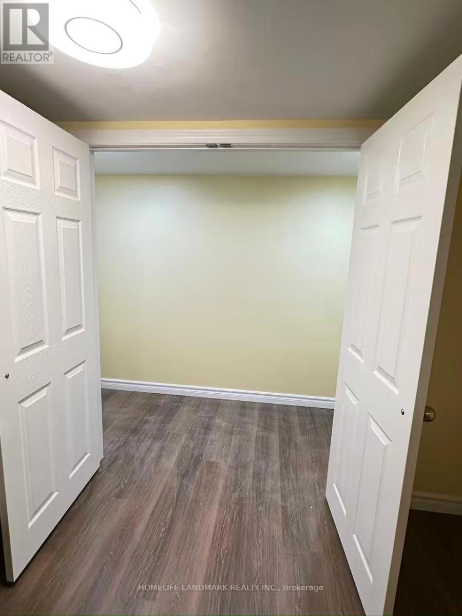 A room with a white door and wooden flooring.