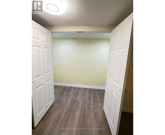 A room with a white door and wooden flooring.