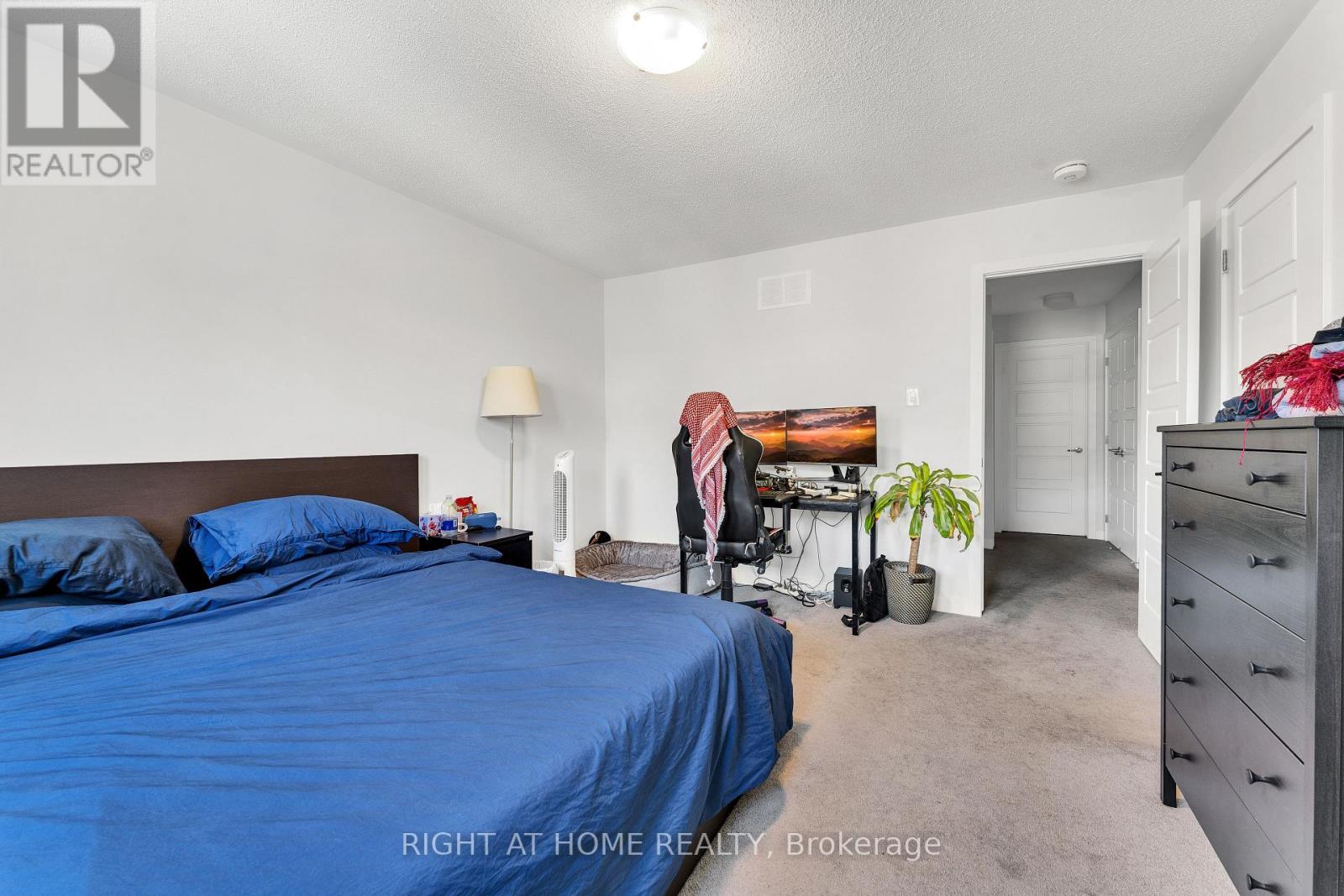 A bedroom with a blue bedspread and a bed with two pillows.
