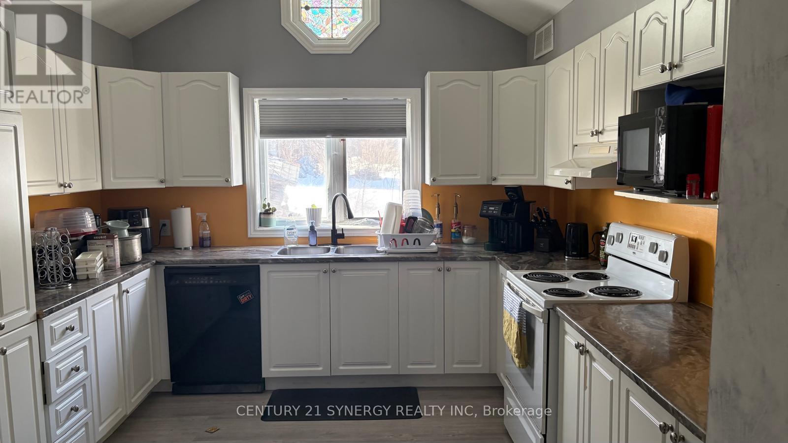 A kitchen with white cabinets and a stove top oven.
