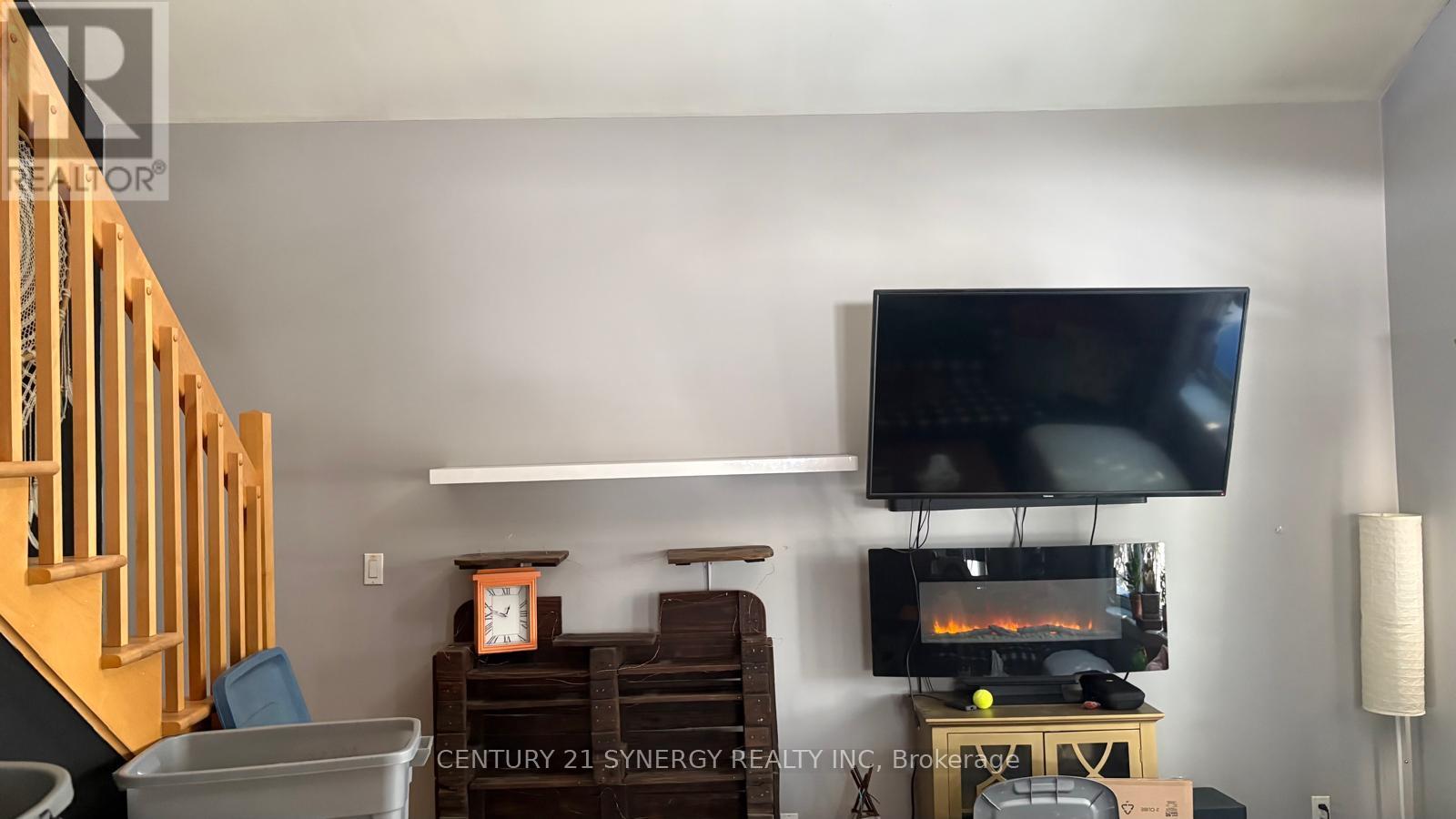 A living room with a television and a fireplace.
