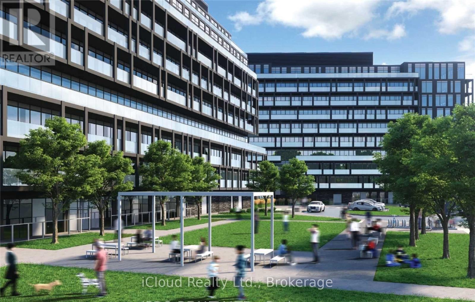 A modern building with a glass facade and a courtyard with people walking and sitting.