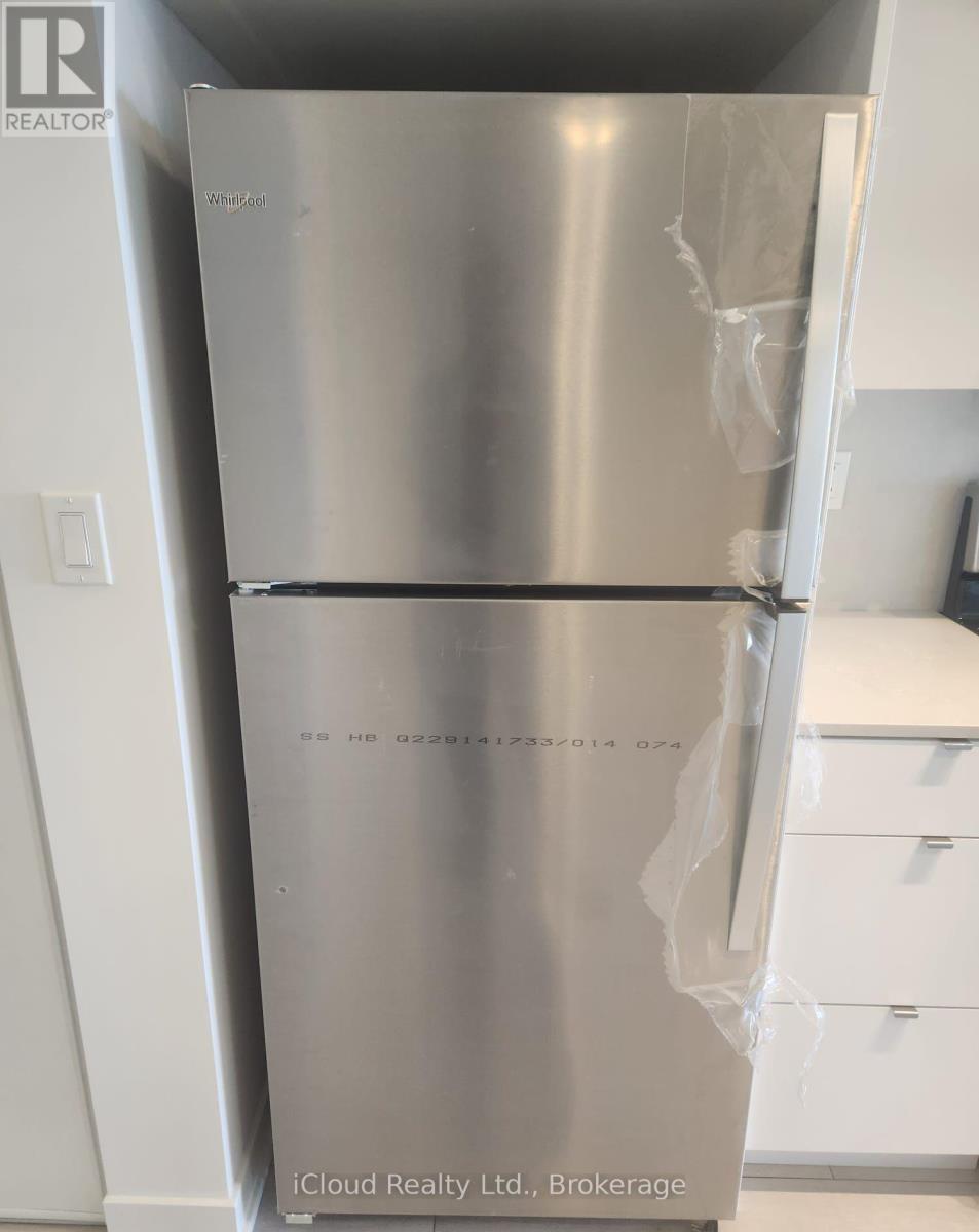 A silver fridge with the door open and a plastic bag hanging on the door.