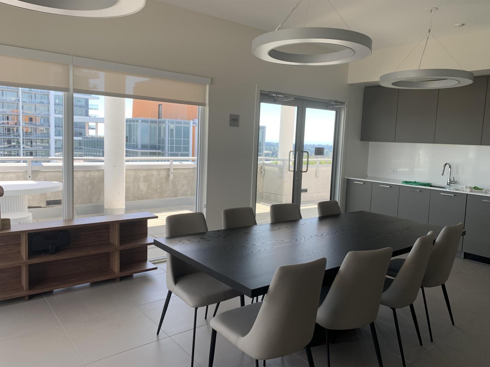 A modern dining room with a large table and chairs.