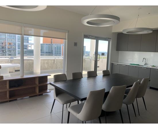 A modern dining room with a large table and chairs.