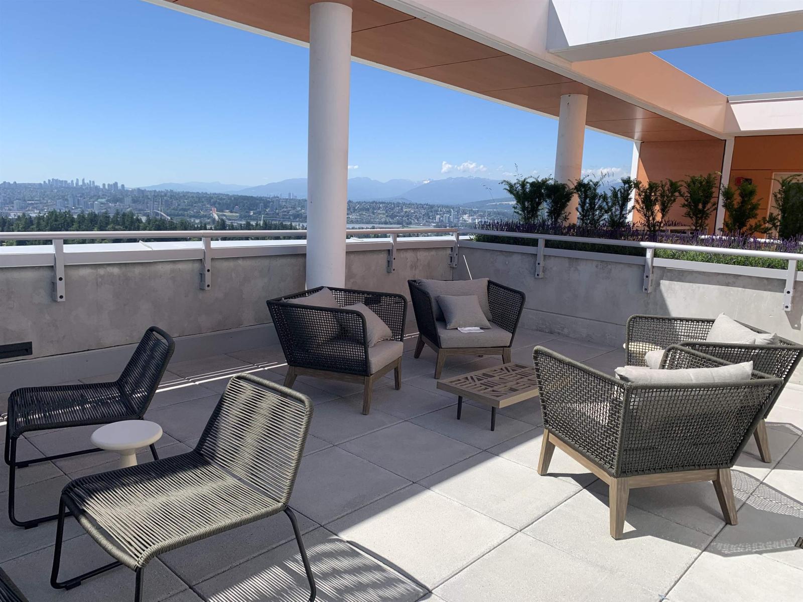 A patio with a view of the city and mountains.