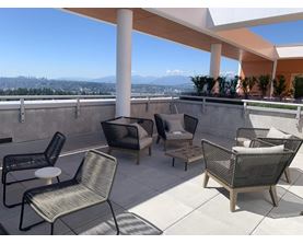 A patio with a view of the city and mountains.