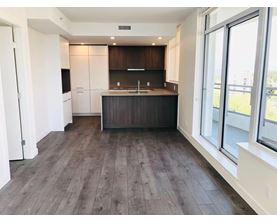A kitchen with dark wood floors and white walls.