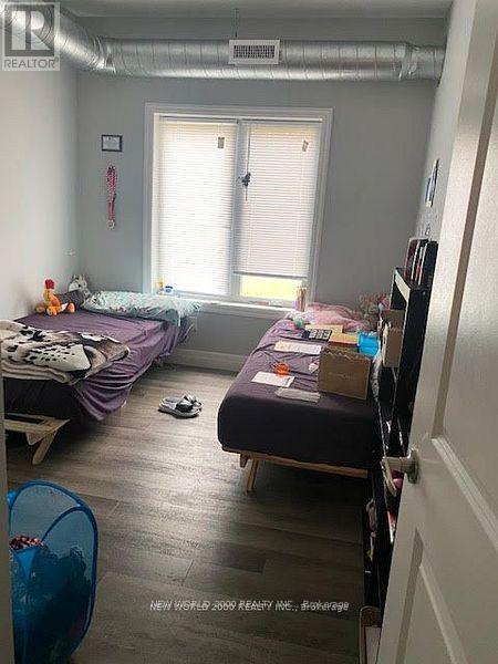 A bedroom with two beds and a window.