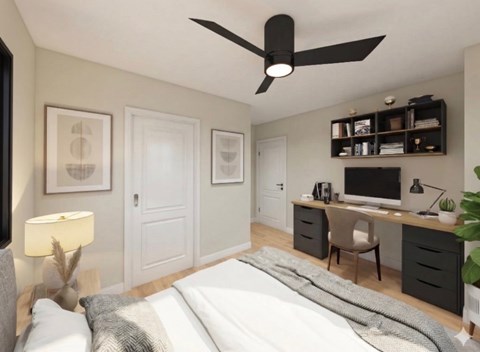 A bedroom with a bed, desk, and chair.
