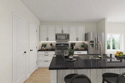 A kitchen with white cabinets and a black countertop.