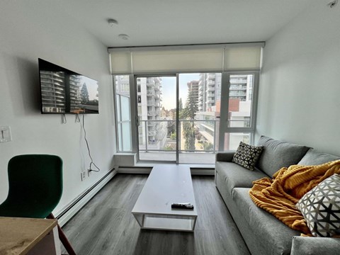 A living room with a grey couch and a white coffee table.