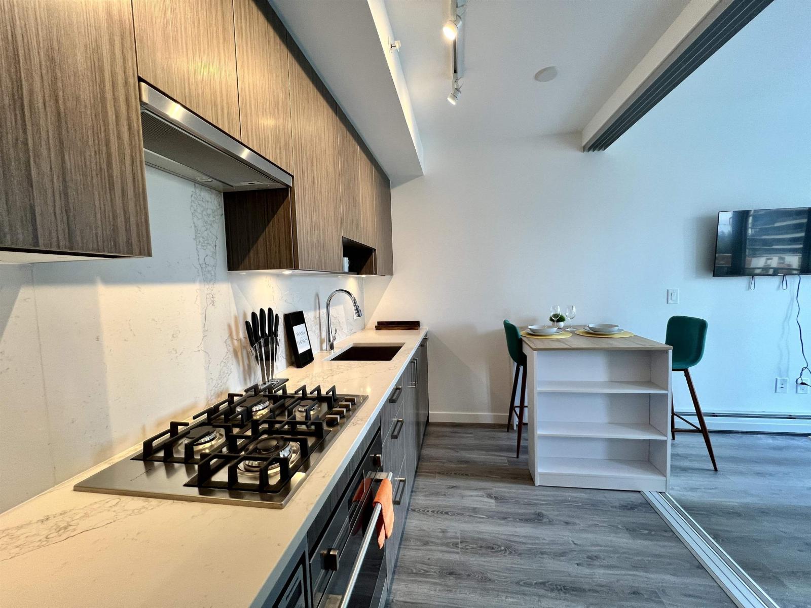 A kitchen with a stove and a dining table.