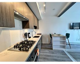 A kitchen with a stove and a dining table.
