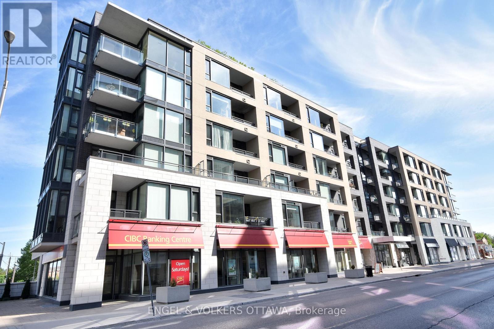 A modern multi-story building with a red awning and a sign that reads "Cleaning Centre".