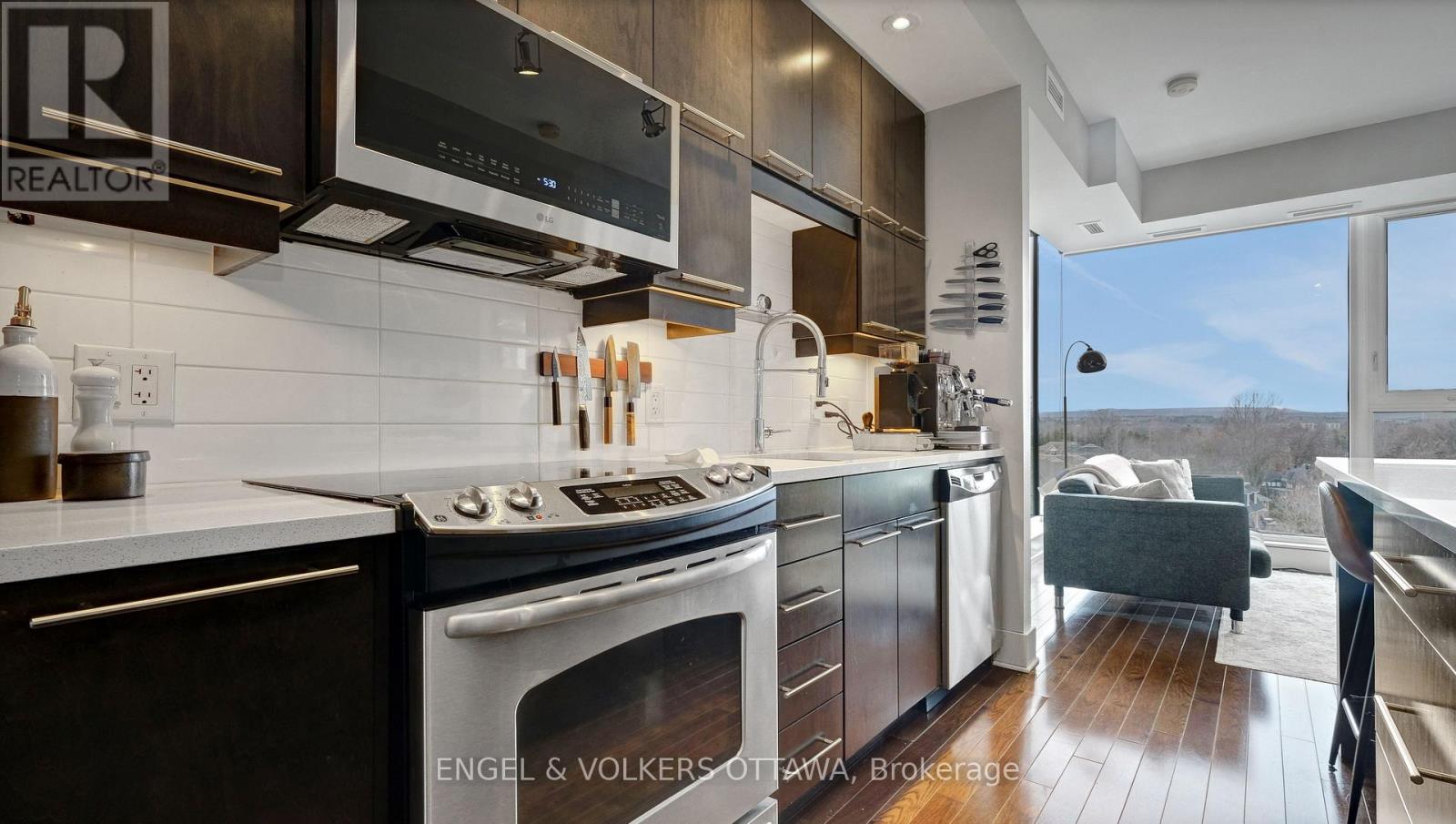 A modern kitchen with dark wood cabinets and a stainless steel refrigerator.