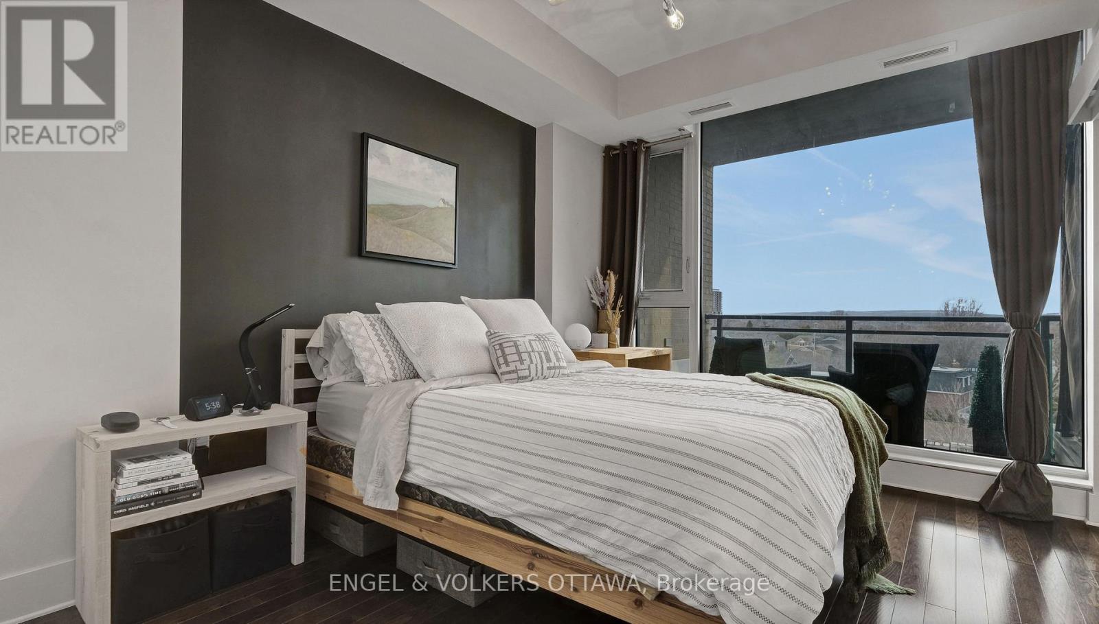 A bedroom with a large bed and a window overlooking the ocean.