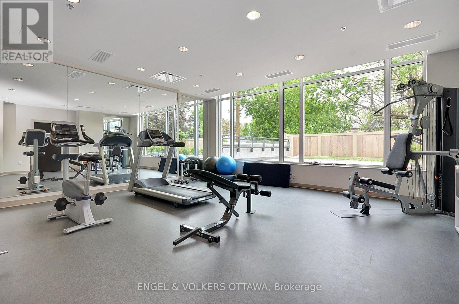 A gym with a variety of equipment including treadmills, weights, and exercise machines.