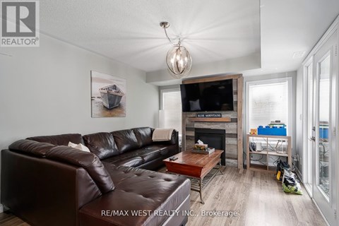 A living room with a brown leather couch and a painting of a boat on the wall.