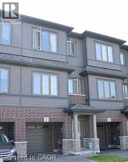 A two story house with a garage on the bottom floor.