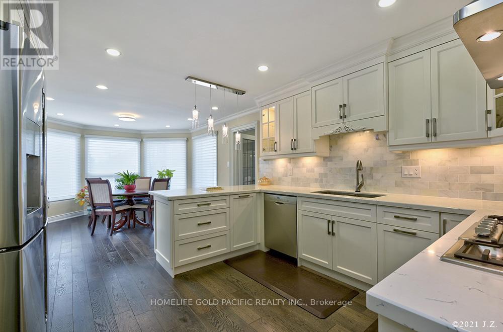 A kitchen with white cabinets and a marble countertop.