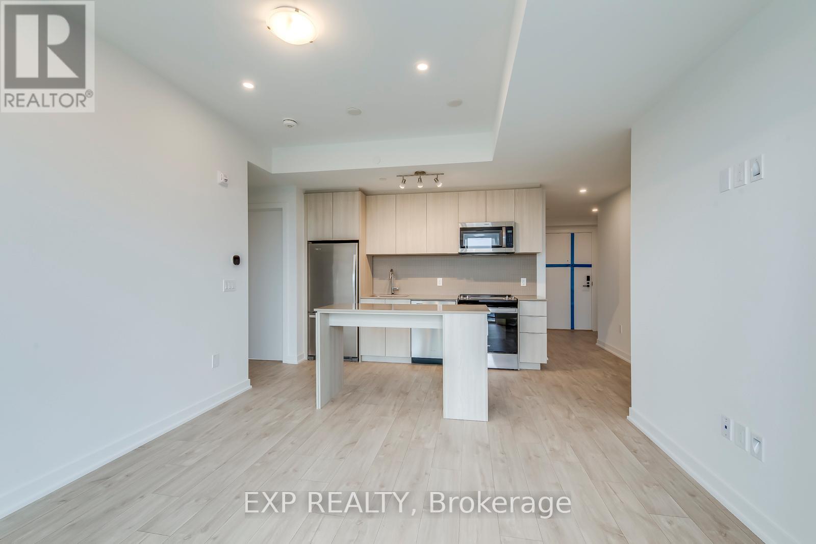 A spacious kitchen with a dining table and chairs in a white room.