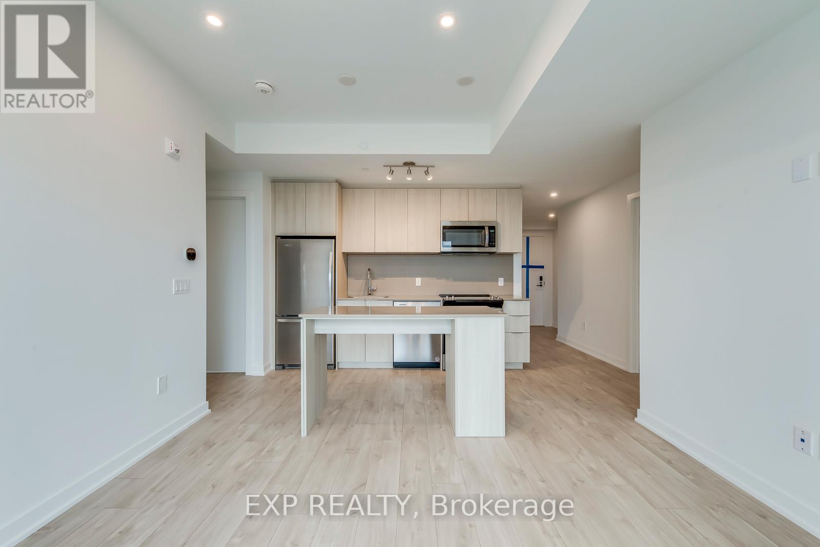 A white kitchen with a table and chairs in the middle of the room.