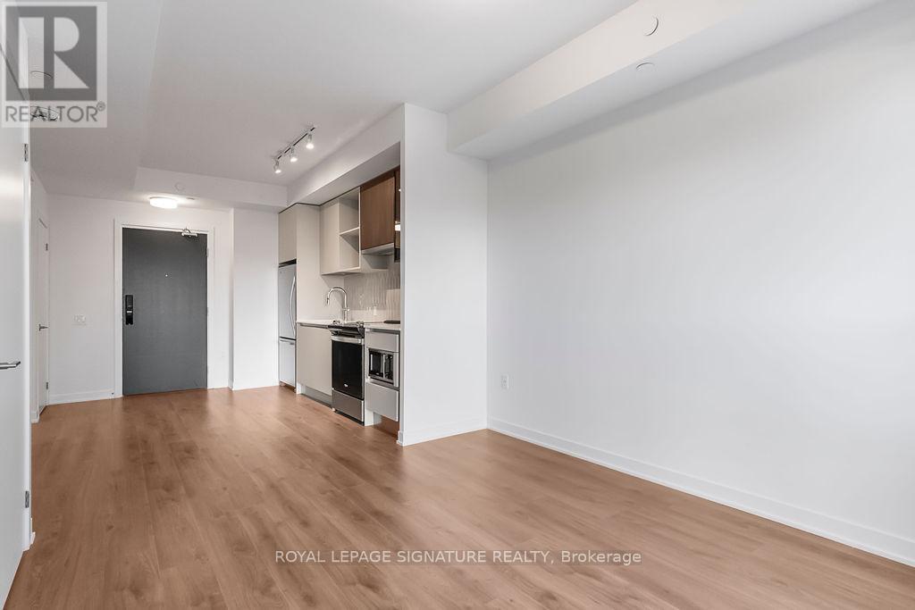 A spacious, empty room with wooden floors and white walls.