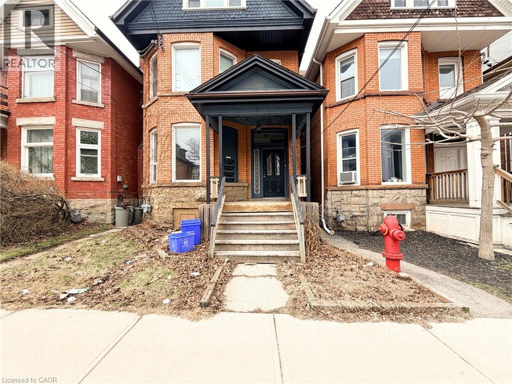 A house with a black front door and a red fire hydrant.