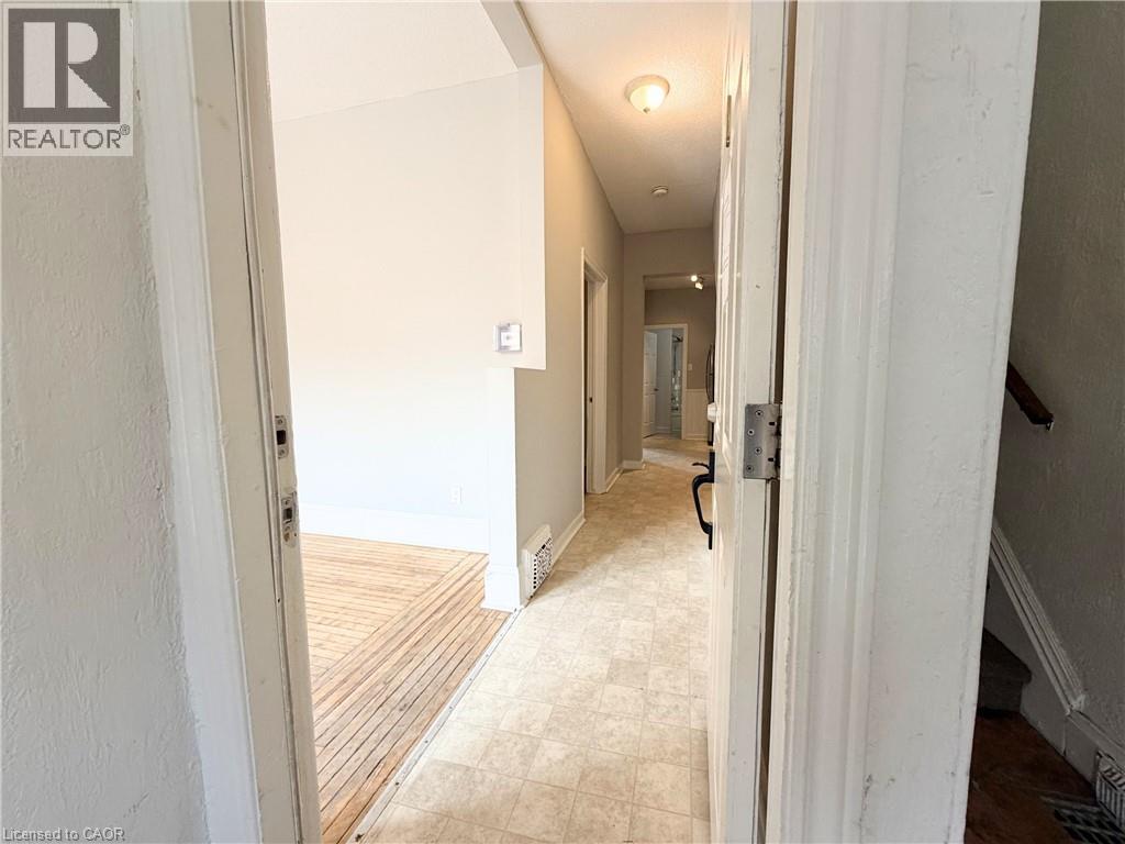 A hallway with a wooden floor and white walls.