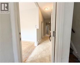 A hallway with a wooden floor and white walls.