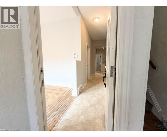 A hallway with a wooden floor and white walls.