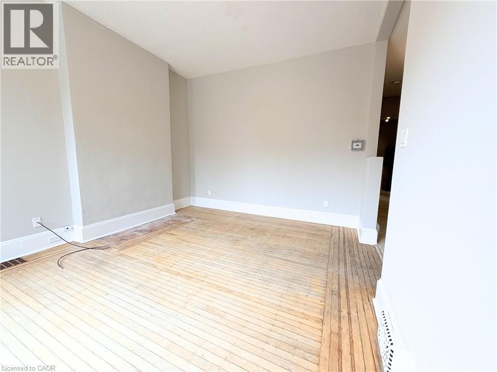 A room with wooden flooring and white walls.
