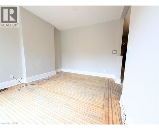 A room with wooden flooring and white walls.