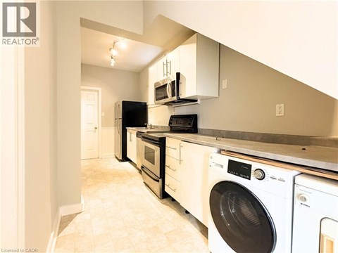 A realtor image of a kitchen with white appliances.