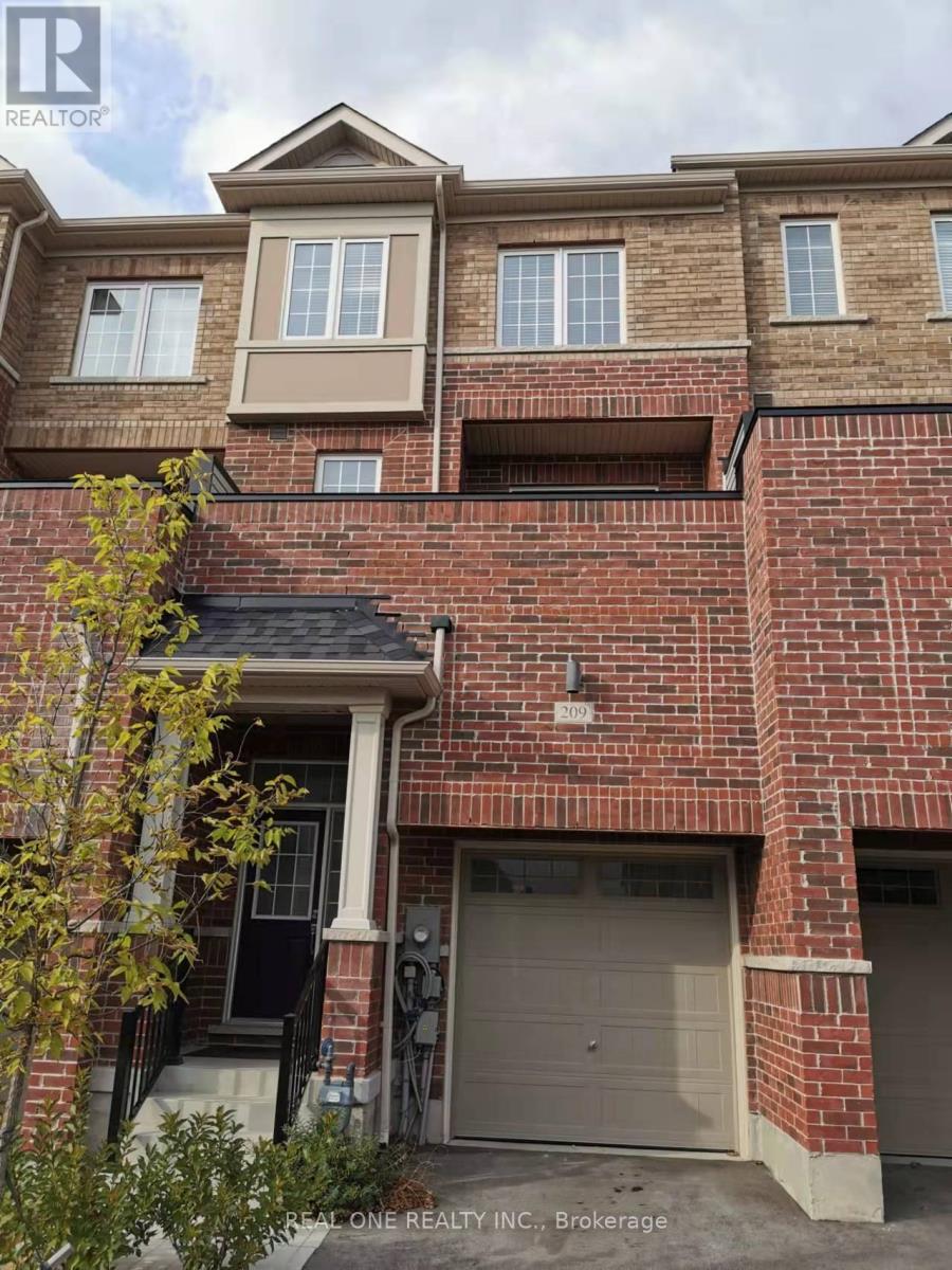 A brick house with a garage door and a tree in front.