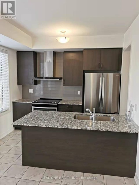 A modern kitchen with granite countertops and stainless steel appliances.