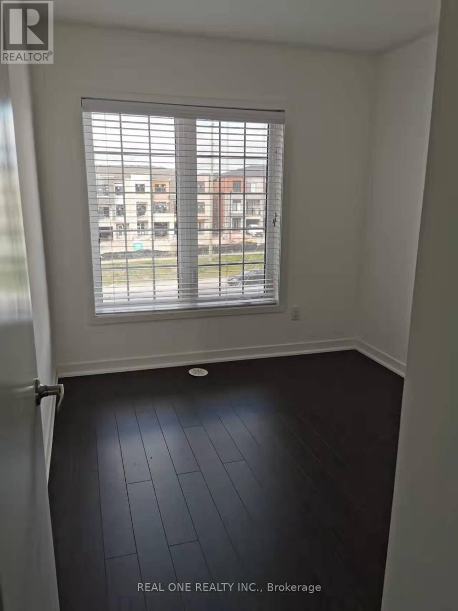 A room with a window and a view of a parking lot and buildings outside.